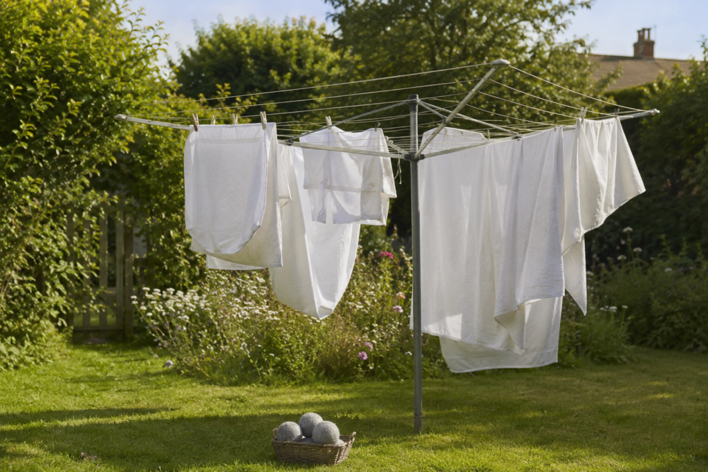 Laundry line drying in a British garden with wool dryer balls in a basket in the foreground
